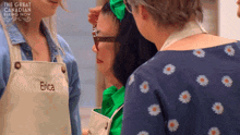 three women are standing next to each other and one of them has the name erica embroidered on her apron