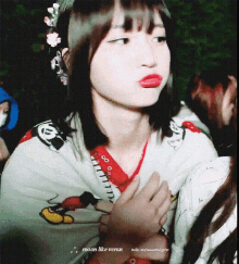 a girl wearing a mickey mouse shirt making a face