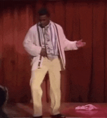 a man in a suit and tie is dancing on a stage .