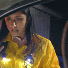 a woman wearing a yellow jacket that says s.d. on it