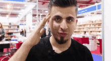 a man with a beard is making a peace sign with his hand