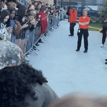 a man in an orange shirt is standing in front of a crowd