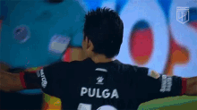 a soccer player with the name pulga on the back of his shirt