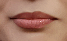 a close up of a woman 's lips with pink lipstick on .