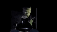 a man is smoking a cigarette in a dark room .