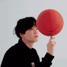 a person is holding a basketball with a smiley face on it .
