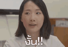 a woman in a white shirt is making a funny face with a foreign language on the bottom
