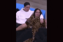 a man and a woman are sitting next to each other on a couch in a stadium .