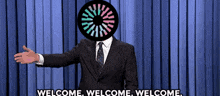 a man in a suit and tie is giving a welcome