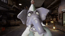 a cartoon elephant is wearing a party hat and making a face