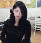 a woman in a black shirt is sitting in front of a computer screen