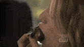 a woman is eating a piece of meat with the words one tree hill above her mouth