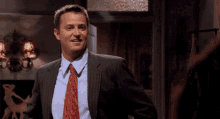 a man in a suit and tie is smiling and looking at the camera