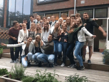 a group of people posing for a picture in front of a building with a sign that says ' nl ' on it