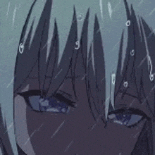 a close up of a person 's face in the rain with water drops on it .