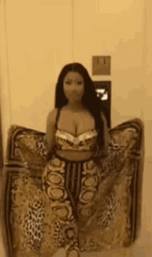 a woman is standing in a room wearing a leopard print dress and a crop top .