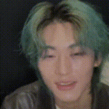 a close up of a person 's face with green hair and a black background .