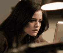 a close up of a woman looking at a laptop