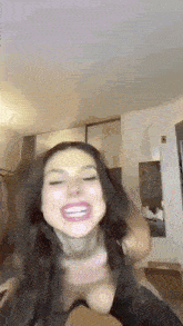 a woman is sitting on someone 's shoulders in a room and smiling .