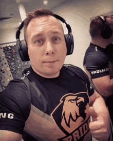 a man wearing headphones is wearing a shirt that says pride