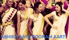 a group of women are dancing with the words abhika aayu poonam aarti in blue