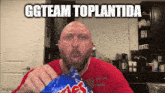 a bald man in a red shirt is eating a bag of cheetos with a caption that says ggteam toplantida