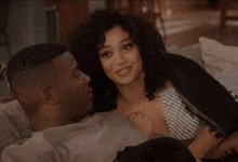 a man and a woman are laying on a couch