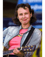 a woman in a pink shirt is holding a guitar with the brand name fender on it