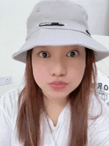 a woman wearing a bucket hat looks surprised and confused