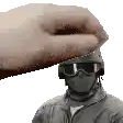 a soldier wearing a helmet and goggles is being patted by a hand .