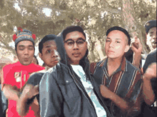 a group of young men are posing for a picture and one of them is wearing a hat that says " baguio "