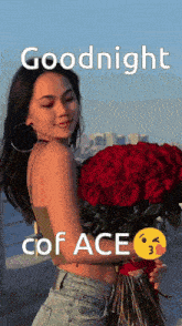 a woman is holding a large bouquet of red roses and says goodnight cof ace .