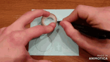 a person is drawing a circle on a piece of paper with the words made in animotica below it