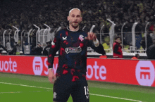 a soccer player with the number 18 on his jersey stands on the field