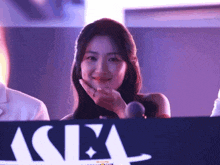 a woman is behind a sign that says asia