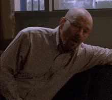 a bald man wearing glasses and a striped shirt