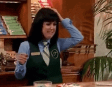 a woman wearing a green vest with the letter t on the front