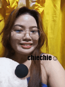 a woman wearing glasses is smiling with the name chiechie on her shoulder