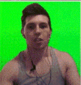 a man wearing headphones and a tank top against a green screen