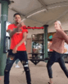 a man and a woman are standing next to each other and dancing in a room .