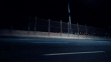 a blue sports car is driving down a dark road