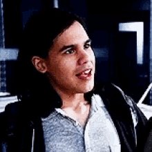 a close up of a man with long hair wearing a hoodie .