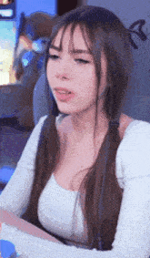 a woman with long hair and pigtails is sitting in front of a computer screen .