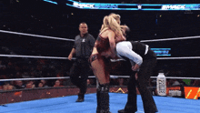 a woman in a wrestling ring with a bottle of smith 's on the floor