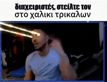 a man in a blue shirt is looking at something with greek writing on the bottom