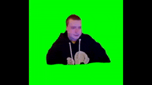 a man is laying on his back on a green screen and drinking from a bottle .