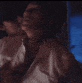 a man is kissing a woman 's neck in a dark room