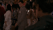 a group of people are dancing at a party with a man wearing a name tag that says " a "