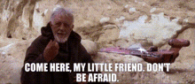 a man with a beard is holding a sword and saying come here my little friend don 't be afraid