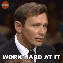 a man in a suit and tie with the words work hard at it below him